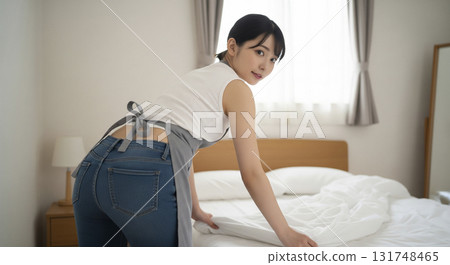 A lady making the bed 131748465