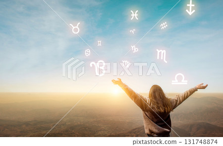 Woman raising hands looking at the sky. Astrological wheel, choose a zodiac sign. Astrology and horoscopes concept. Woman raising hands looking at the sky. Astrological wheel, choose a zodiac sign. Astrology and horoscopes concept. 131748874