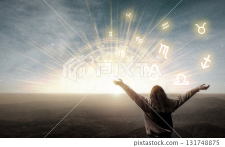 Woman raising hands looking at the sky. Astrological wheel, choose a zodiac sign. Astrology and horoscopes concept. Woman raising hands looking at the sky. Astrological wheel, choose a zodiac sign. Astrology and horoscopes concept. 131748875