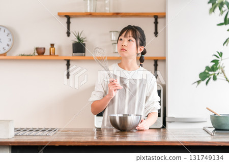 Children (elementary school, junior high school, high school, girls) who are struggling with making sweets in the kitchen at home Children (elementary school, junior high school, high school, girls) who are struggling with making sweets in the kitchen at home 131749134