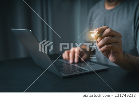Close-up businessman hand User Interacting with Digital Checklist on Laptop Screen, Concept of Task Management, Productivity, Remote Work, and Organization in Modern Life 131749238