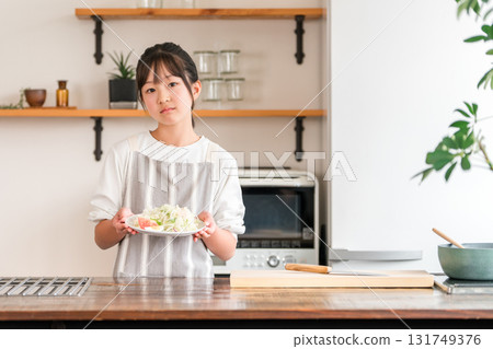 Child, girl, kids holding vegetables in the kitchen (troubled, dislikes vegetables, likes and dislikes) 131749376