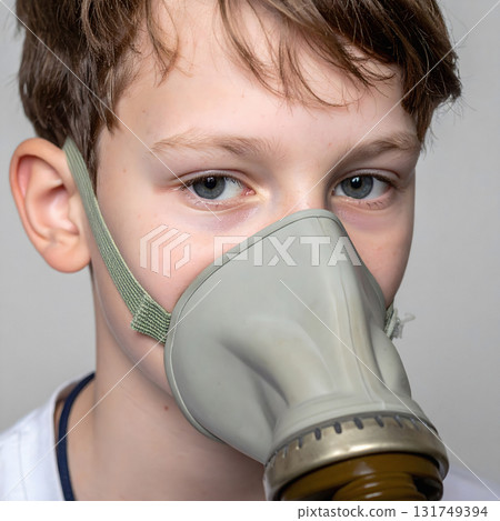 Young boy wearing protective gas mask with blue eyes 131749394