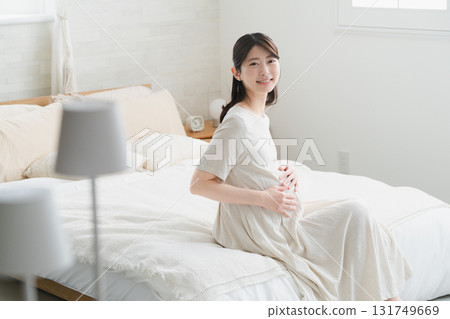 Pregnant woman relaxing in bed lifestyle image 131749669