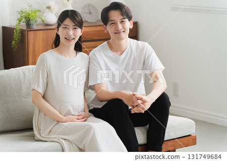 A couple relaxing on the sofa in the living room Lifestyle image A couple relaxing on the sofa in the living room Lifestyle image 131749684