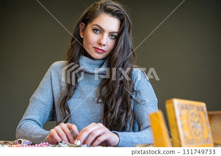 reflection of a woman in mirror choosing and trying different jewelry, soft focus, closeup reflection of a woman in mirror choosing and trying different jewelry, soft focus, closeup 131749733