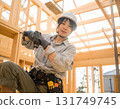 A young female carpenter building a house, a scene from a construction site focusing on her facial expression and hands while working 131749745