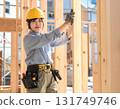 A young female carpenter building a house, a scene from a construction site focusing on her facial expression and hands while working 131749746