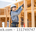 A young female carpenter building a house, a scene from a construction site focusing on her facial expression and hands while working 131749747