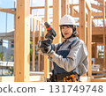 A young female carpenter building a house, a scene from a construction site focusing on her facial expression and hands while working 131749748