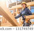 A young female carpenter building a house, a scene from a construction site focusing on her facial expression and hands while working 131749749