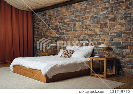 Cozy bedroom with stone wall and rustic furnishings for a relaxing atmosphere Cozy bedroom with stone wall and rustic furnishings for a relaxing atmosphere 131749770