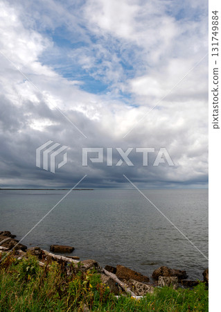 Dramatic storm clouds gathering above calm coastal waters Dramatic storm clouds gathering above calm coastal waters 131749884