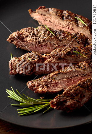 Grilled beef steak on a black plate. 131750654