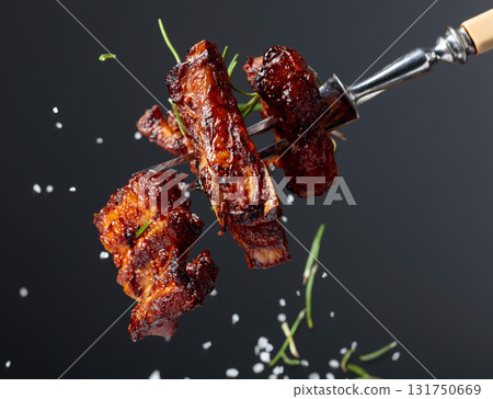 Grilled pork belly with rosemary on a fork. Grilled pork belly with rosemary on a fork. 131750669