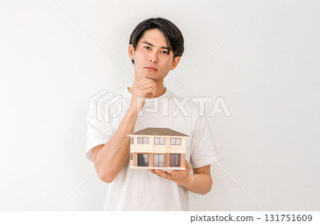 年輕的亞洲男子拿著房屋模型(我的家,獨立式住宅,房屋建築,思考,困擾) 年輕的亞洲男子拿著房屋模型(我的家,獨立式住宅,房屋建築,思考,困擾) 131751609