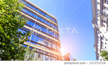 Glass office building surrounded with green trees.  Eco-friendly office building. Sustainable architecture of city reducing heat carbon dioxide modern city environment. 131751728