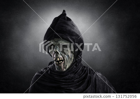 Portrait of a zombie with hooded cape over dark misty background 131752056