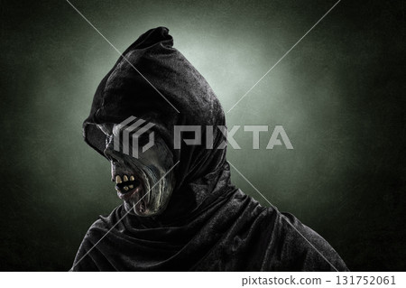 Portrait of a zombie with hooded cape over dark misty background Portrait of a zombie with hooded cape over dark misty background 131752061