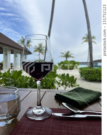 Glass of Red Wine with Maldives Paradise Background Glass of Red Wine with Maldives Paradise Background 131752123