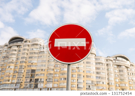 No entry sign against modern apartment building with cloudy sky background 131752454