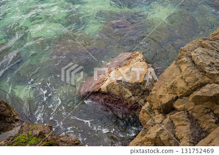 Rocky coastal scene with clear water and seaweed 131752469