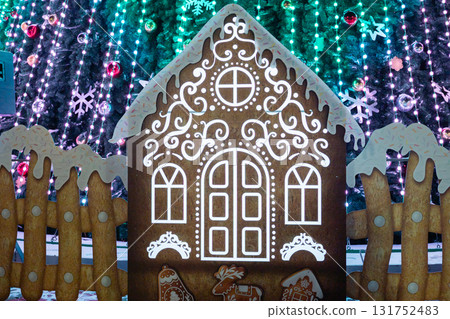 Festive gingerbread house with icing and decorated lights for holiday celebration Festive gingerbread house with icing and decorated lights for holiday celebration 131752483