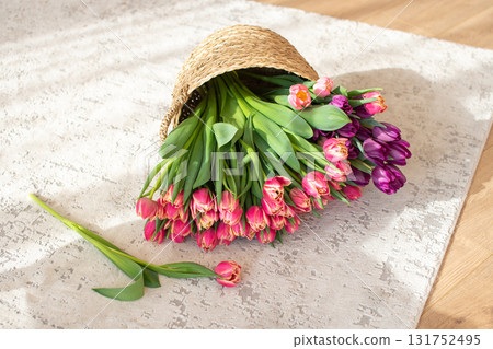 Tulips Spilling from Wicker Hat on Wooden Floor 131752495