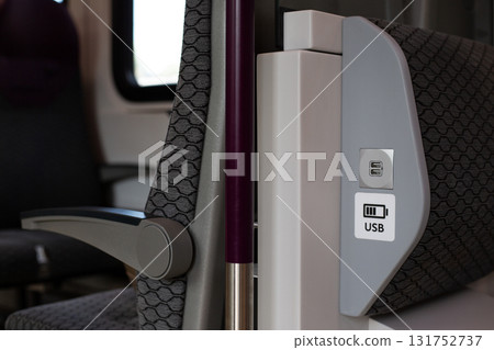 Modern train seat with built in USB charging port, providing convenience for passengers to charge devices during travel. Functional design enhances comfort and connectivity on move Modern train seat with built in USB charging port, providing convenience for passengers to charge devices during travel. Functional design enhances comfort and connectivity on move 131752737