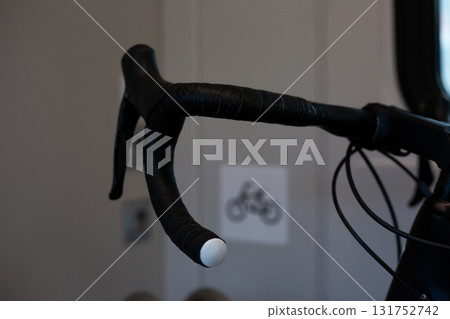 Bicycle handlebar, featuring black grips and a clean, sleek design, with a visible bike icon in the background, highlighting modern urban transport elements 131752742