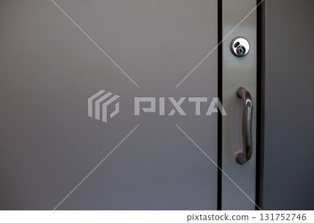 Door with a modern handle and lock. The sleek design and smooth surface of door are emphasized, offering minimalist and contemporary aesthetic 131752746