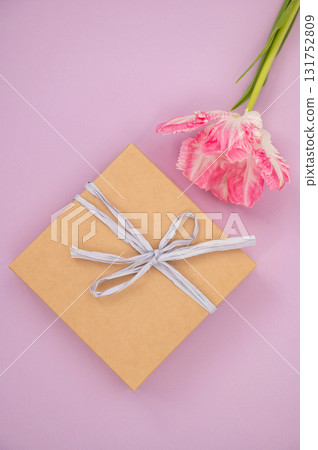 Gift box with ribbon and pink flower on pastel background. Teacher's Day in Uzbekistan 131752809