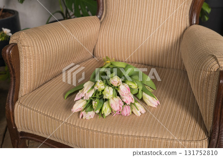 Bouquet of pink and white tulips on vintage armchair 131752810