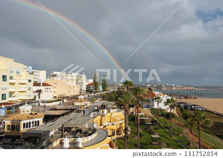 Coastal beachfront with rainbow over vibrant resort Coastal beachfront with rainbow over vibrant resort 131752854