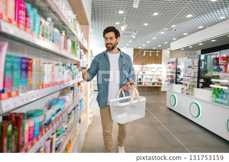 Bearded man picking medicine in pharmacy Bearded man picking medicine in pharmacy 131753159