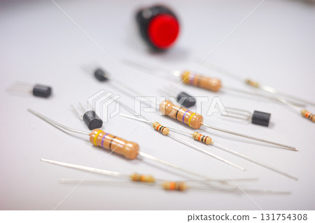 Electronic components on white background, close-up of resistors, transistors and red push button for DIY electronics projects. Electronic components on white background, close-up of resistors, transistors and red push button for DIY electronics projects. 131754308