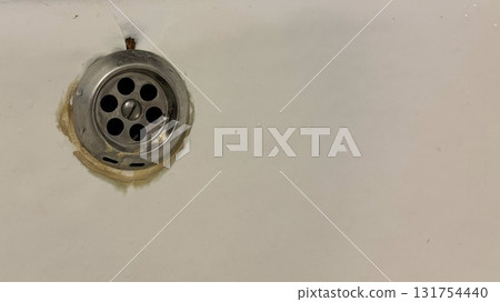 A close-up of an old bathtub drain against the background of old chipped enamel 131754440