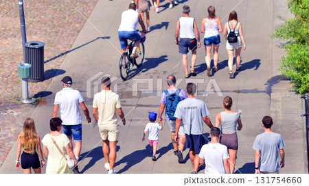 Warsaw, Poland. 15 August 2025. Tourists and residents crossing promenade along the Vistula river crowded. Groups of people walking together crossing a promenade on a weekend day. Warsaw, Poland. 15 August 2025. Tourists and residents crossing promenade along the Vistula river crowded. Groups of people walking together crossing a promenade on a weekend day. 131754660