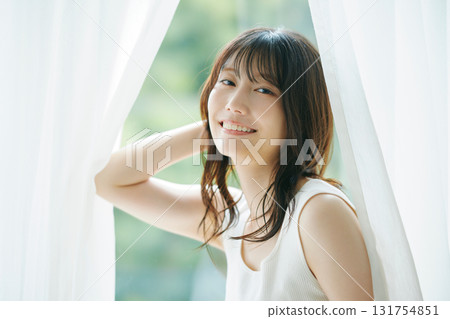 Beauty image: A woman opening the curtains Beauty image: A woman opening the curtains 131754851