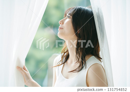 Beauty image: A woman opening the curtains Beauty image: A woman opening the curtains 131754852