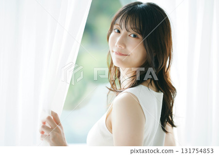 Beauty image: A woman opening the curtains Beauty image: A woman opening the curtains 131754853