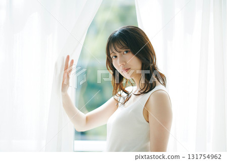 Beauty image: A woman opening the curtains 131754962