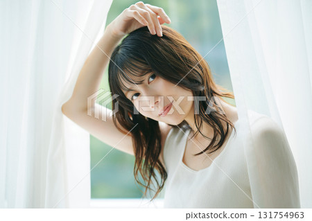 Beauty image: A woman opening the curtains 131754963