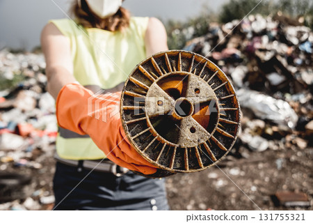 Woman volunteer helps clean the field of nuclear waste and plastic garbage 131755321