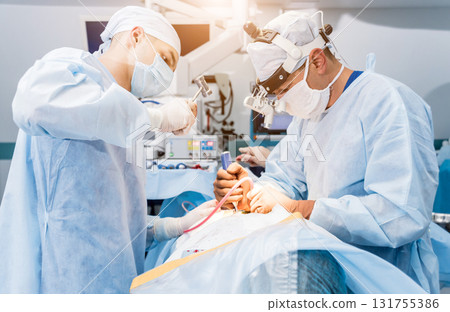 Spinal surgery. Group of surgeons in operating room with surgery equipment.  131755386