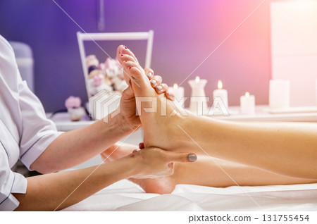 Beautiful young woman enjoying foot massage in spa salon. Cosmetology Beautiful young woman enjoying foot massage in spa salon. Cosmetology 131755454