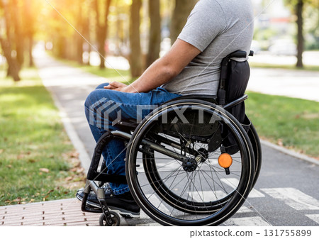 Handicapped man in wheelchair preparing to cross the road on pedestrian crossing Handicapped man in wheelchair preparing to cross the road on pedestrian crossing 131755899