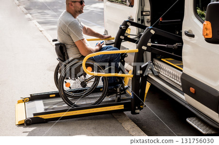 A man in a wheelchair on a lift of a vehicle for people with disabilities A man in a wheelchair on a lift of a vehicle for people with disabilities 131756030