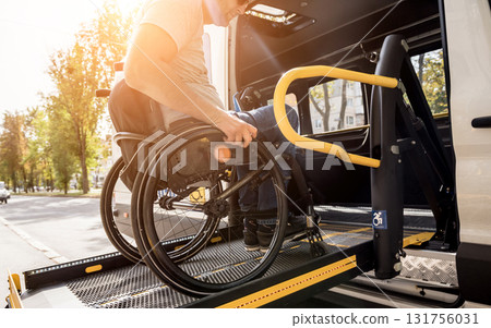 A man in a wheelchair on a lift of a vehicle for people with disabilities A man in a wheelchair on a lift of a vehicle for people with disabilities 131756031