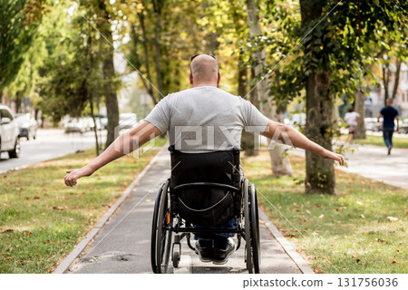 Handicapped man in wheelchair walk at the park alley Handicapped man in wheelchair walk at the park alley 131756036